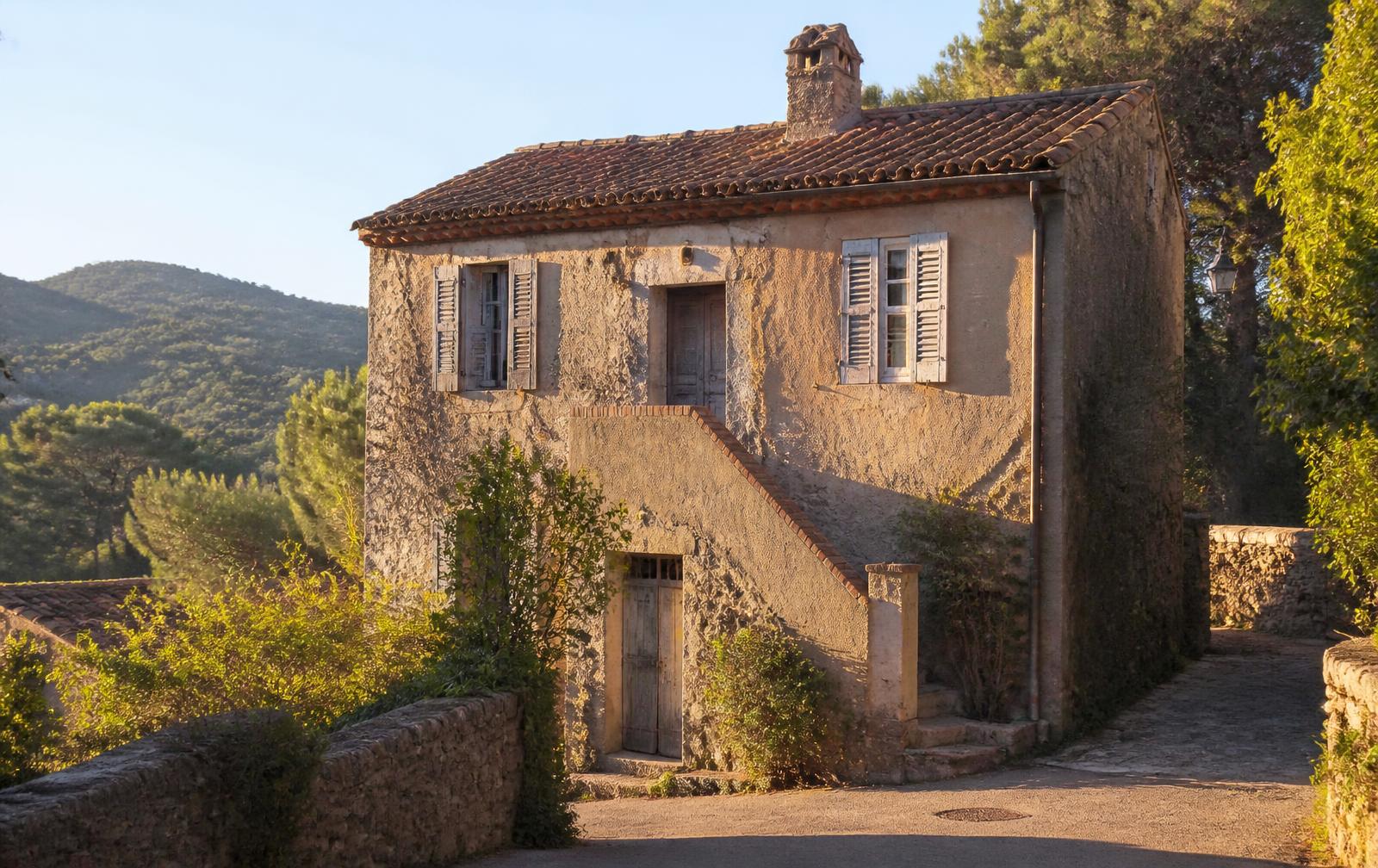 Maison de village en pierre à rénover, volets patinés, adossée aux collines boisées du Var